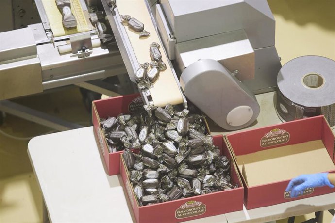 Archivo - Los polvorones de chocolates llegan a una caja por una cinta transportadora durante la visita a la fábrica de mantecados de la firma La Muralla en la localidad de Estepa. Imagen de archivo.