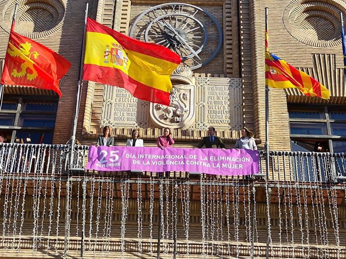 Colocación de la pancarta 25-N en el balcón principal del Ayuntamiento de Zaragoza