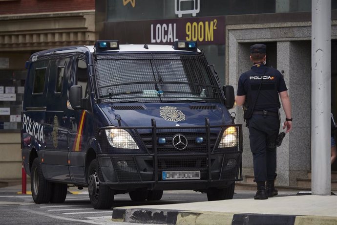 Archivo - Imagen de archivo de una furgoneta y un agente de la Policía Nacional.