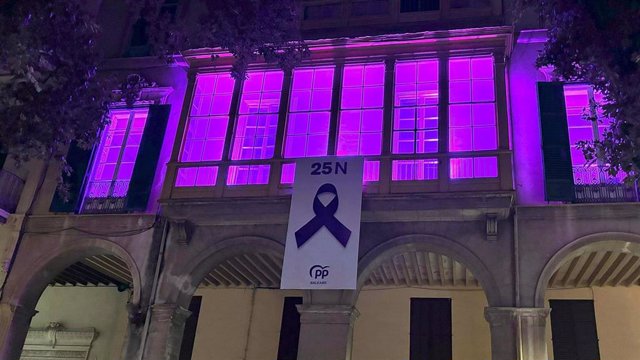 El PP de Baleares ilumina su sede y despliega una lona con motivo del 25N.