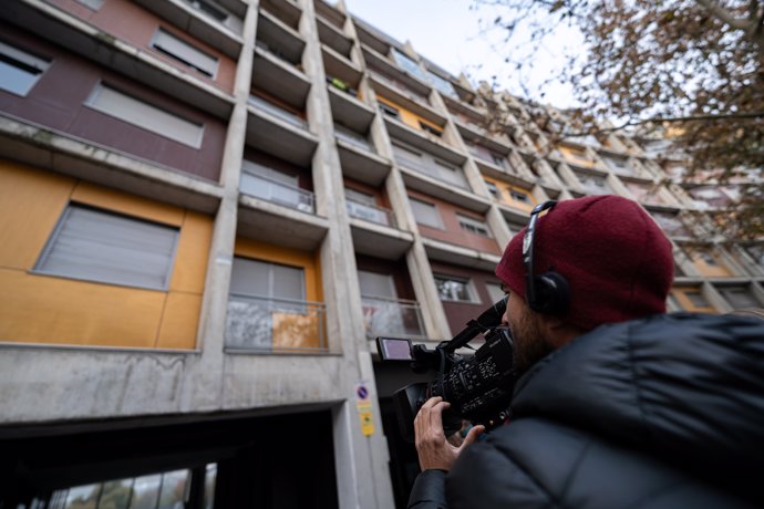 Un cámara de televisión graba el bloque de pisos donde se ha producido el doble asesinato, en la calle Jacobeo del barrio de Carabanchel, a 27 de noviembre de 2023, en Madrid (España). 