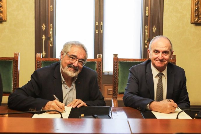 El decano del Icab, Jesús Sánchez, y el director de Cáritas Diocesana de Barcelona, Eduard Sala, firman un convenio de colaboración.