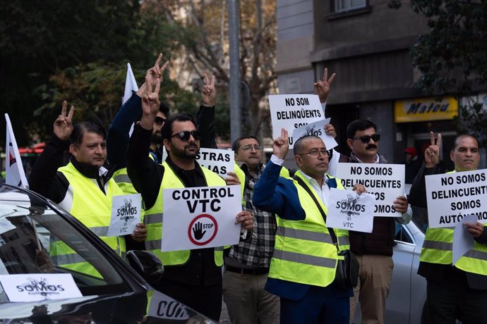 Trabajadores del sector de la VTC sujetan pancartas durante una manifestación en Barcelona.