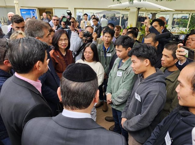 Los ministros de Exteriores de Tailandia e Israel, Parnpree Bahiddha Nukara y Eli Cohen, respectivamente, con varios rehenes tailandeses liberados.