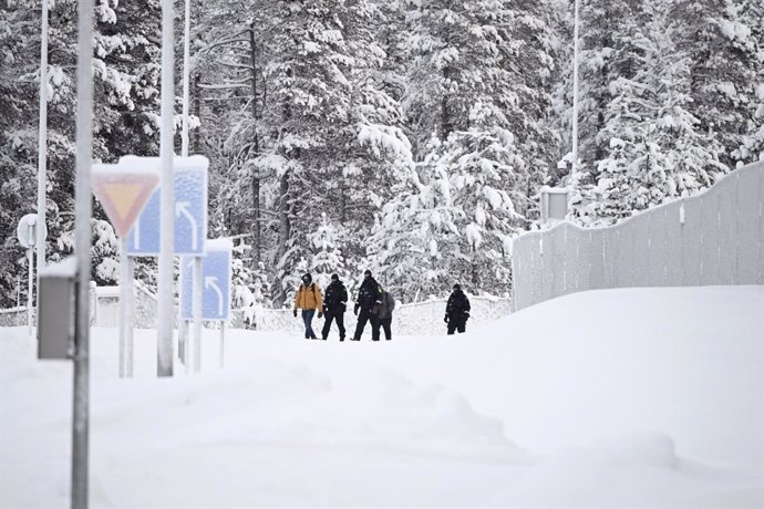 27 November 2023, Finland, Inari: Finnish Border Guards escort two migrants at the Raja-Jooseppi international border crossing station. Raja-Jooseppi in the far north of Finnish Lapland is the only crossing point open on the country's eastern border. Th