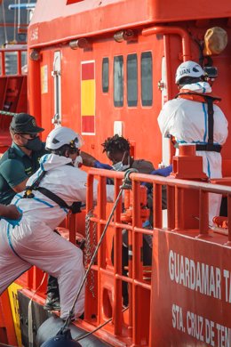 Archivo - Trabajadores ayudan a una mujer a salir de la embarcación 'Guardamar Talía’ a su llegada al muelle de Arguineguín con varias decenas de migrantes, a 28 de agosto de 2021, en Arguineguín, Mogán, Gran Canaria, (España). El muelle de Arguineguín re