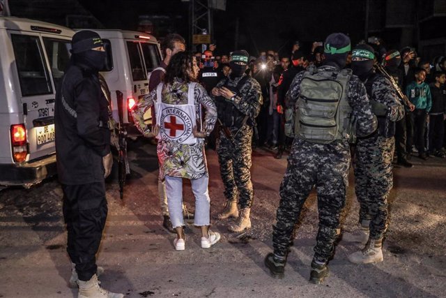 28 November 2023, Palestinian Territories, Rafah: Hamas and Islamic Jihad fighters hand over newly released hostages to the Red Cross in Rafah, as part of a hostages-prisoners swap deal between Hamas and Israel. Photo: Stringer/dpa