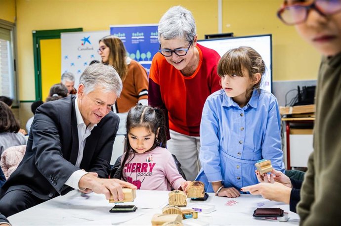 Menores de la Asociación Valdeperales que han participado en El vaivén de la Feria junto al director territorial de CaixaBank en Madrid, Xicu Costa; y la directora de la Feria del Libro, Eva Orúe.
