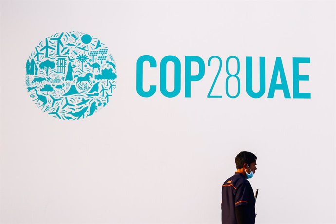 27 November 2023, United Arab Emirates, Dubai: A worker walks in front of th logo of 2023 United Nations Climate Change Conference (COP28 UAE), which takes place on 30 November until 12 December 2023 in Expo City Dubai. ire Photo: Beata Zawrzel/ZUMA Press