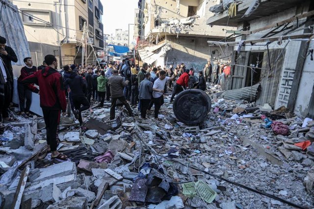 Civiles palestinos inspeccionan el lugar de un ataque en Rafá, en la Franja de Gaza