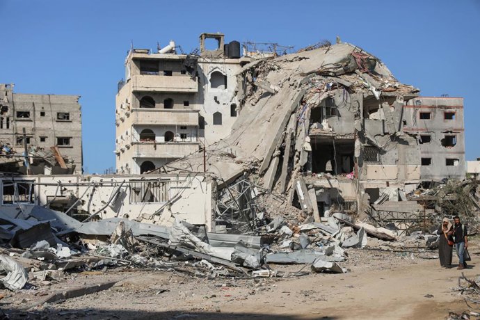 GAZA, Nov. 29, 2023  -- People walk past destroyed buildings in Gaza City, on Nov. 29, 2023. After weeks of Israeli strikes on Gaza in retaliation for an attack on Oct. 7 by Hamas against Israel, the two sides reached a four-day humanitarian truce last 