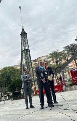 El alcalde de Murcia, José Ballesta, acompañado por el teniente de alcalde y concejal de Desarrollo Urbano y Ciudad Inteligente, José Guillén, y el edil de Cultura e Identidad, Diego Avilés, supervisa el montaje del gran árbol de Navidad