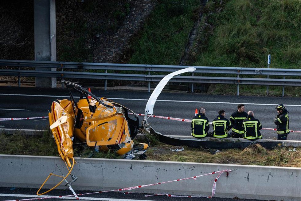 Varios bomberos junto a un helicóptero tras un accidente en la carretera M-40, 