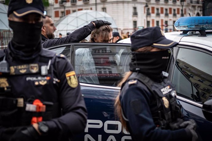 Un agente de Policía Nacional lleva a un detenido a comisaría.