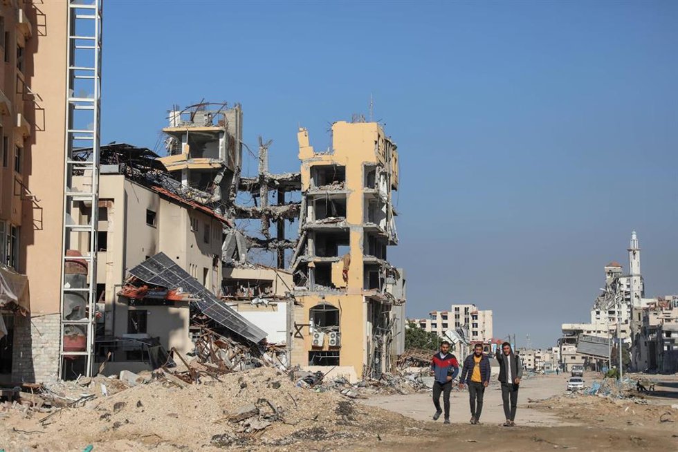 GAZA, Nov. 29, 2023  -- People walk past destroyed buildings in Gaza City, on Nov. 29, 2023. After weeks of Israeli strikes on Gaza in retaliation for an attack on Oct. 7 by Hamas against Israel, the two sides reached a four-day humanitarian truce last 