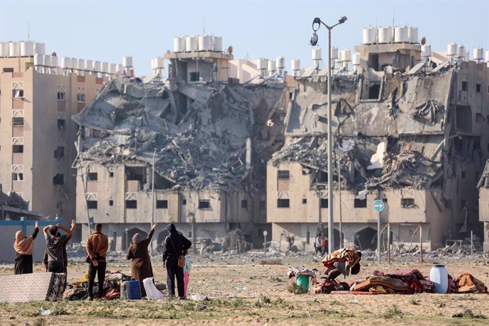 December 2, 2023, Gaza, Palestine: Palestinians in the Qatari-funded Hamad Town residential complex in Khan Yunis in the southern Gaza Strip, walk in front of the destroyed buildings  as they flee their homes after an Israeli strike hit 7 towers in the ci