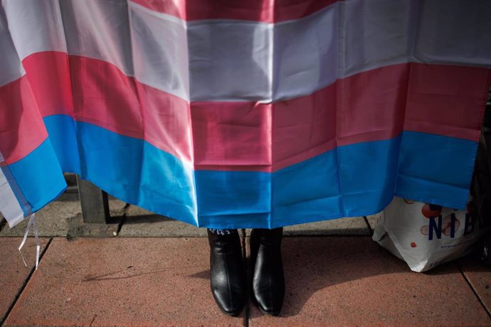 Archivo - Los zapatos de una mujer debajo de una bandera trans.