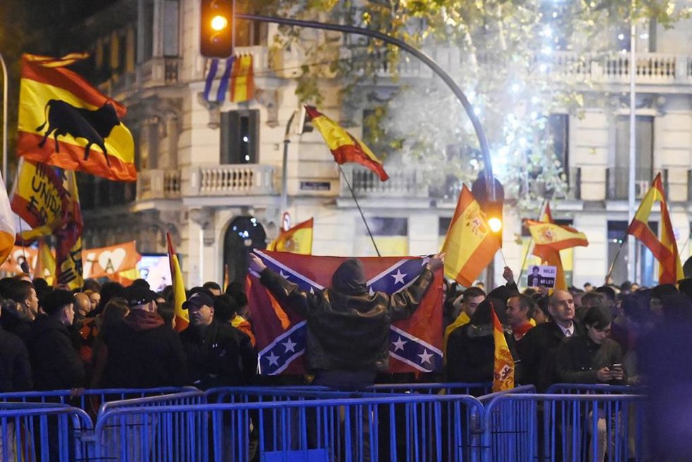 Varias personas portan banderas españolas y una bandera confederada en la calle Ferraz  