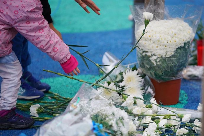 Archivo - Una menor deposita flores en una concentración en el parque donde fue secuestrado un niño.