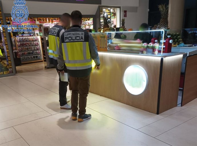 Agentes de la Policía Nacional inspeccionando una de las tiendas.