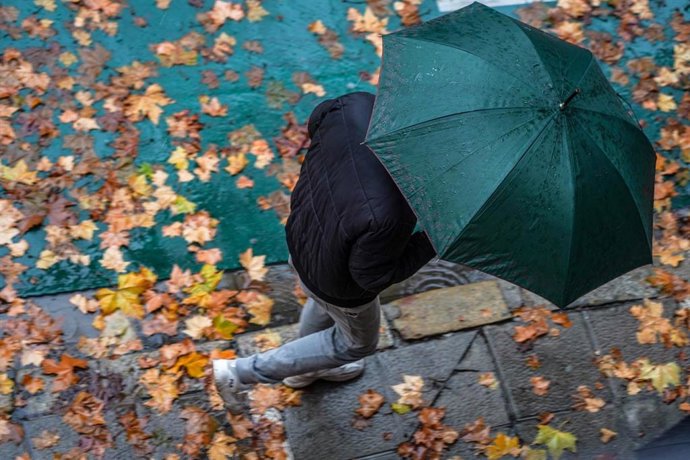 Archivo - Ciudadanos con paraguas por las calles en un día de lluvias intensas y persistente en Sevilla, foto de archivo
