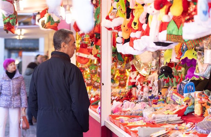 Un hombre observa una caseta del mercadillo de Navidad, en la Plaza Mayor