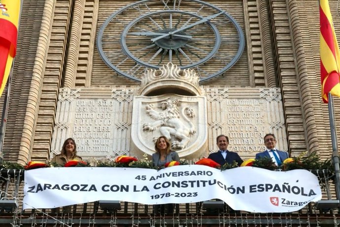 La alcaldesa de Zaragoza y los portavoces municipales, a excepción de ZEC, despliegan una pancarta para conmemorar el 45 aniversario de la Constitución española.