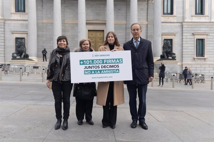 La directora general de la fundación Hay Derecho, Safira Cantos (1i), y la abogada Elisa de la Nuez (2i) posan con una pancarta de las más de las 101.000 firmas recogidas contra la amnistía