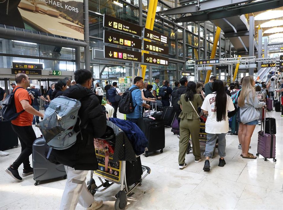 Archivo - Varias personas con maletas en el Aeropuerto Adolfo Suárez Madrid-Barajas