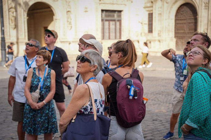 Archivo - Turistas prestan atención al guía que les explicas las curiosidades de la ciudad, a 13 de octubre de 2023, en Sevilla, (Andalucía, España). El puente del 12 de octubre llena de turistas las calles de Sevilla, con unas expectativas del ochenta 