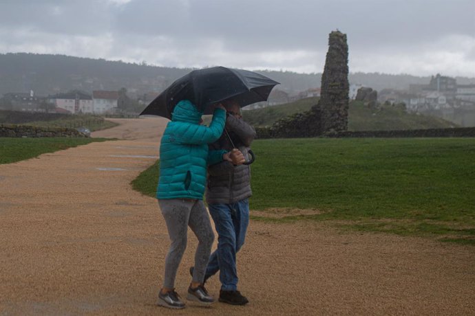 Archivo - Dos personas se protegen de la lluvia con un paraguas, en la playa de A Lanzada, a 5 de noviembre de 2023, en O Grove, Pontevedra, Galicia (España). La borrasca Domingos ha dejado en toda Galicia un total de 1.166 incidencias. En Pontevedra, fue