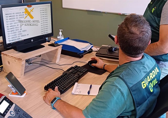 Archivo - Agente de la Guardia Civil frente a un ordenador. Archivo.