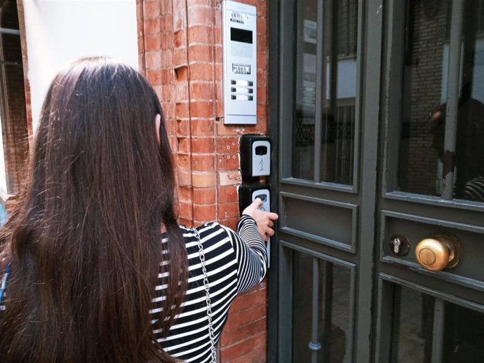 Archivo - Una joven junto a uno de los códigos de acceso utilizados por las viviendas con fines turísticos, en pleno centro de la ciudad.