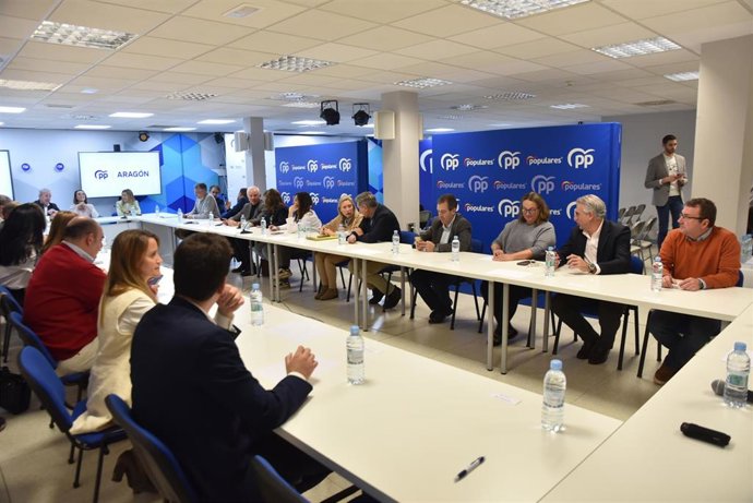 La secretaria general del PP, Cuca Gamarra (6i), y el presidente del Gobierno de Aragón, Jorge Azcón (7i).