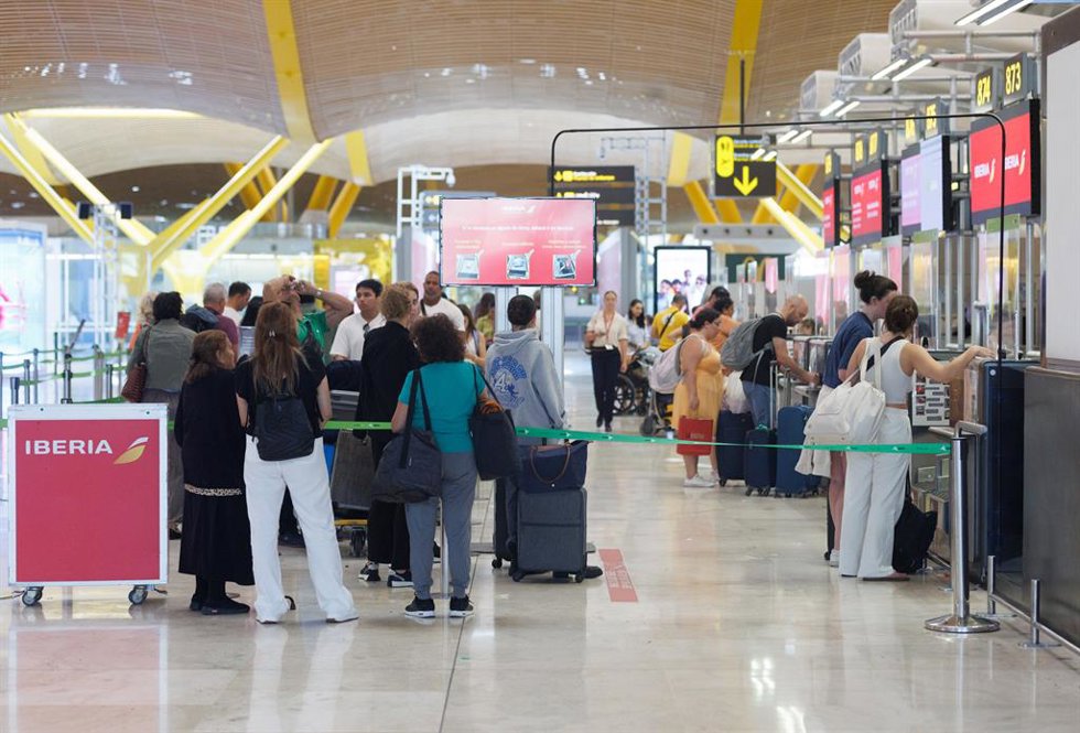 Archivo - Un grupo de personas esperan en uno de los pasillos de facturación de la Terminal T4 del Aeropuerto Adolfo Suárez-Madrid Barajas con motivo de la operación salida de inicios de agosto, a 28 de julio de 2023, en Madrid (España).