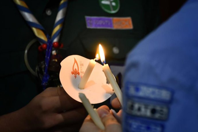 Foto de monitores del movimiento sujetando la Luz de la Paz de Belén