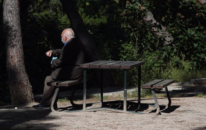 Archivo - Un anciano con mascarilla descansa en el Parque Calero, en el distrito de Ciudad Lineal de la capital, uno de los que el Ayuntamiento de Madrid ha abierto y en los que se permite pasear y hacer ejercicio, en Madrid (España), a 8 de mayo de 202