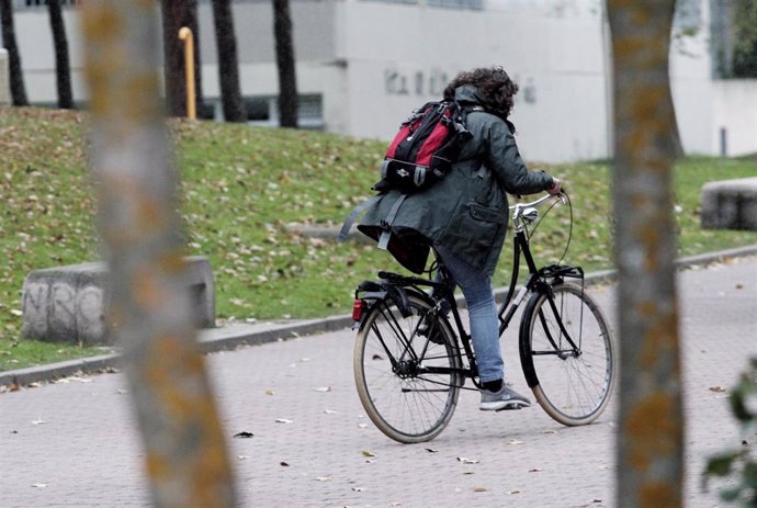 Archivo - Una mujer monta en bici durante el peor temporal del otoño del 2019 en España en el que se verán afectadas 37 provincias avisadas por viento, nieve, oleaje o lluvia, en Madrid a 14 de noviembre de 2019.