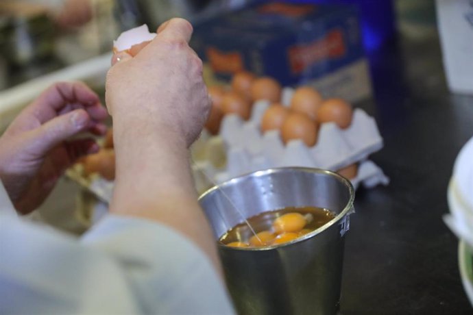 Archivo - Un pastelero casca huevos para la preparación de roscones de Reyes elaborados de forma artesanal en la Pastelería Horno de San Onofre-La Santiaguesa, en Madrid a 3 de enero de 2020.