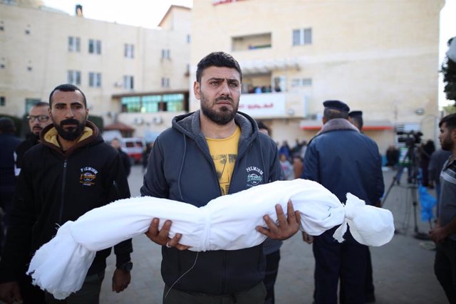 Un hombre traslada el cuerpo de un menor muerto por los bombardeos israelíes sobre la Franja de Gaza.