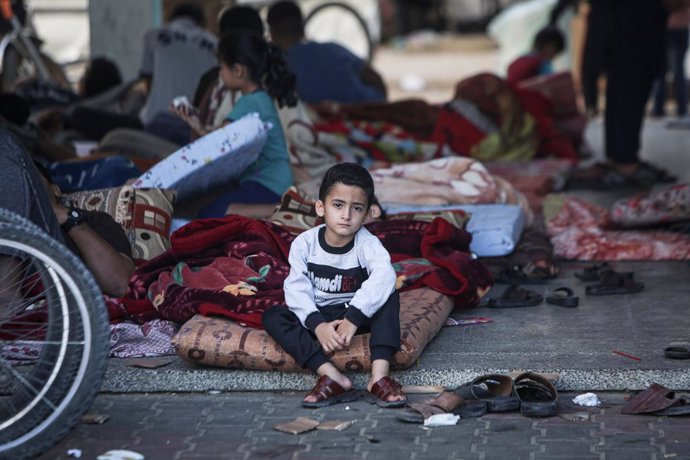 Un niño de cinco años sentado sobre un colchón tener que abandonar su vivienda en Palestina.