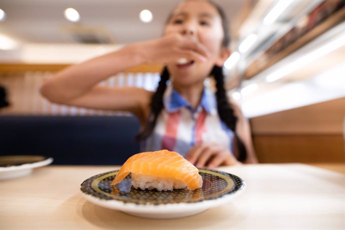 Archivo - Niña comiendo sushi