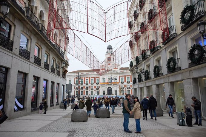 Archivo - Varias personas en una calle comercial frente a la remodelada y peatonalizada Puerta del Sol, a 4 de diciembre de 2022, en Madrid (España). 