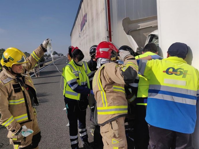 Archivo - Sanitarios y bomberos asisten a un herido en un accidente de tráfico