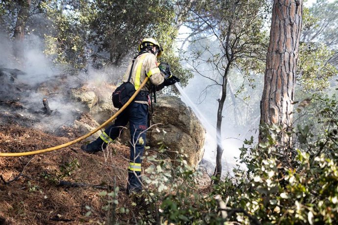 Archivo - Un bombero con una manguera para apagar el fuego del incendio en Argentona, a 24 de junio de 2021, Barcelona, Catalunya (España).