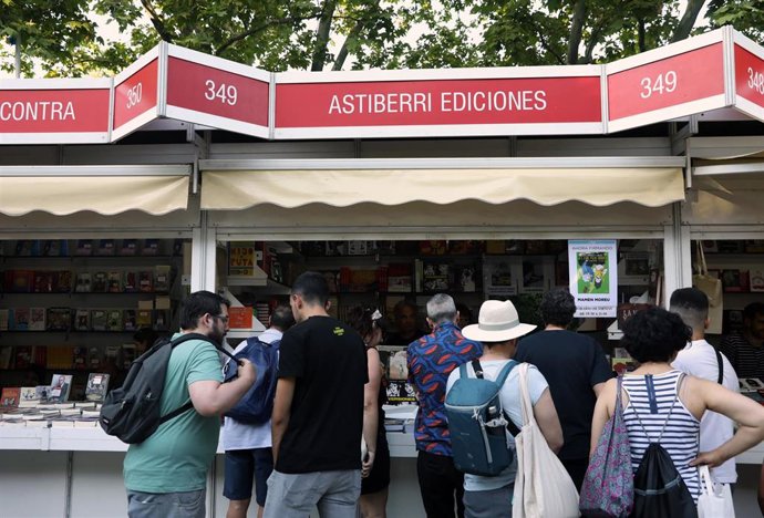 Archivo - Varias personas visitan una caseta de La Feria del Libro de Madrid  