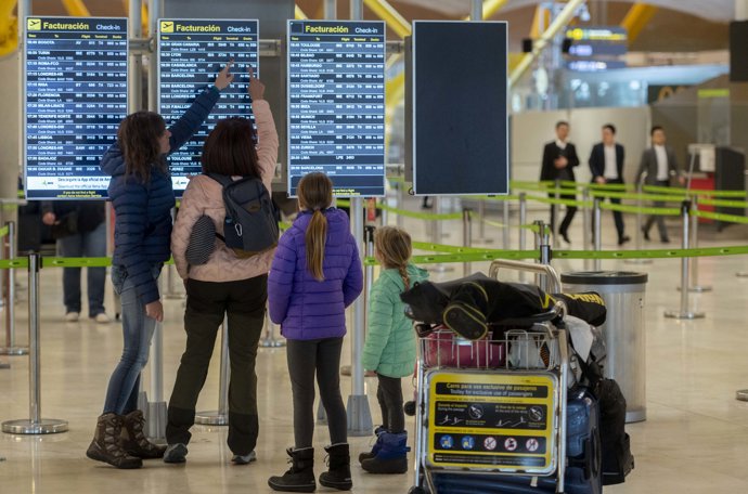 Varias personas observan las salidas de los vuelos con motivo de la operación salida en el puente de diciembre, en el Aeropuerto Adolfo Suárez-Madrid Barajas, a 5 de diciembre de 2023, en Madrid (España). 