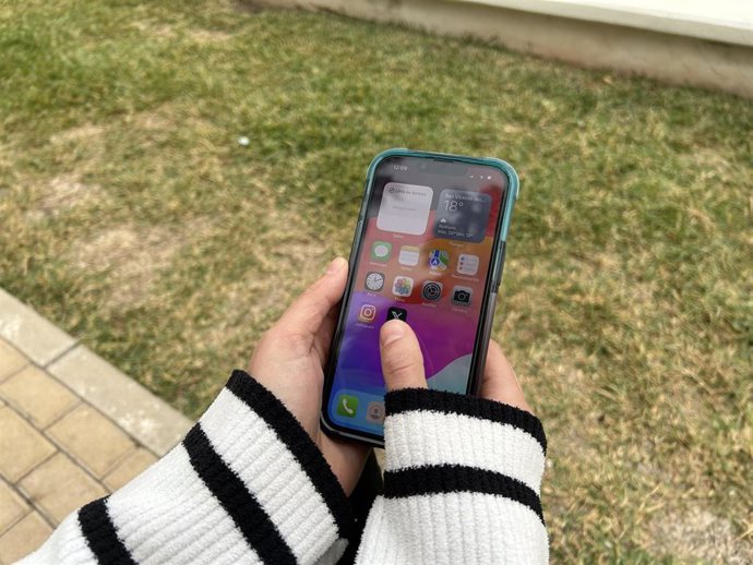 Imagen de archivo de una persona con un móvil.