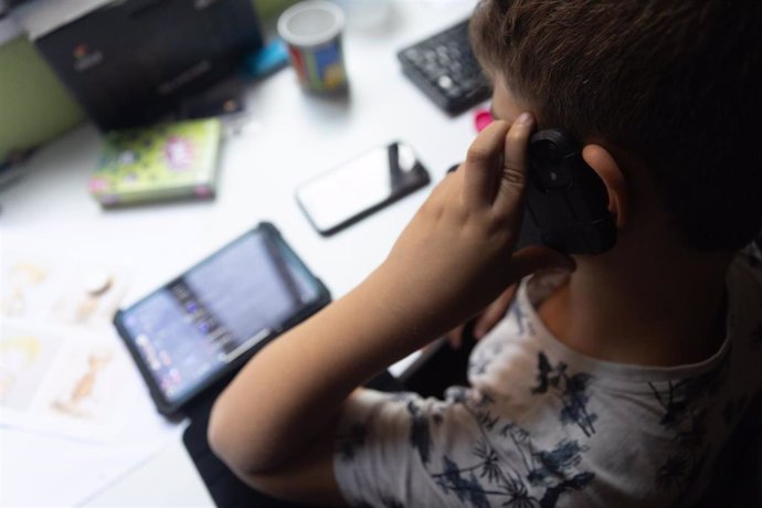 Archivo - Un niño usa el teléfono móvil y una tablet, a 18 de octubre de 2023, en Madrid (España). Según la Vanguardia, en España se estima que el 21% de los adolescentes es adicto a la red y casi la mitad reconoce que tiene "un contacto activo" cada 15 m