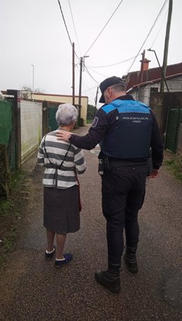 Imagen de un agente ayudando a una anciana.